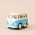 On a neutral background is a pastel blue and ivory vw bus toy. 