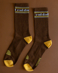 On a brown background is a pair of brown and yellow socks with white text at the top that reads, "rad dad".