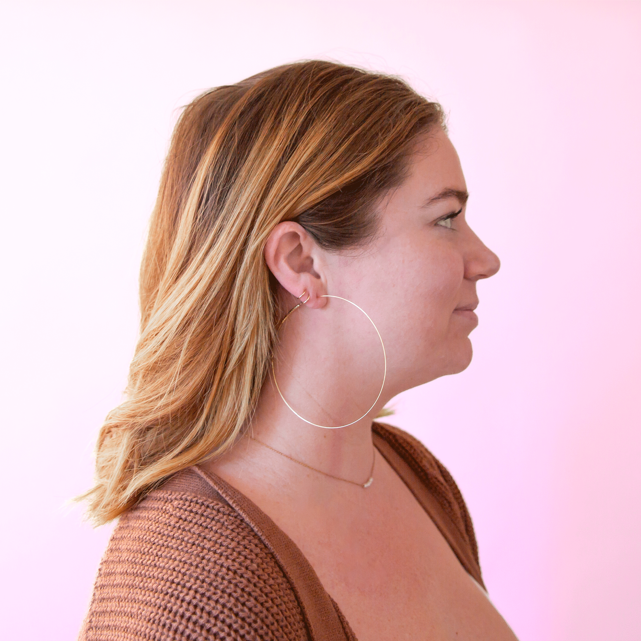 A model wearing the super dainty and large soho hoop earrings. 