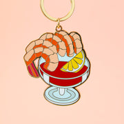 An enamel keychain in the shape of a shrimp cocktail.