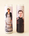 On a white background is a prayer candle with Harry Styles in a dress on the front photographed next to other available Harry Styles prayer candles on our site.