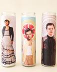 On a white background is a prayer candle with a photo of Harry Styles in front of a watermelon photographed next to other available Harry Styles prayer candles on our site.