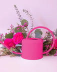 A hot pink metal watering can with a rounded handle and a long spout.