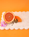 A white marble rectangle cutting board with a scalloped edge.
