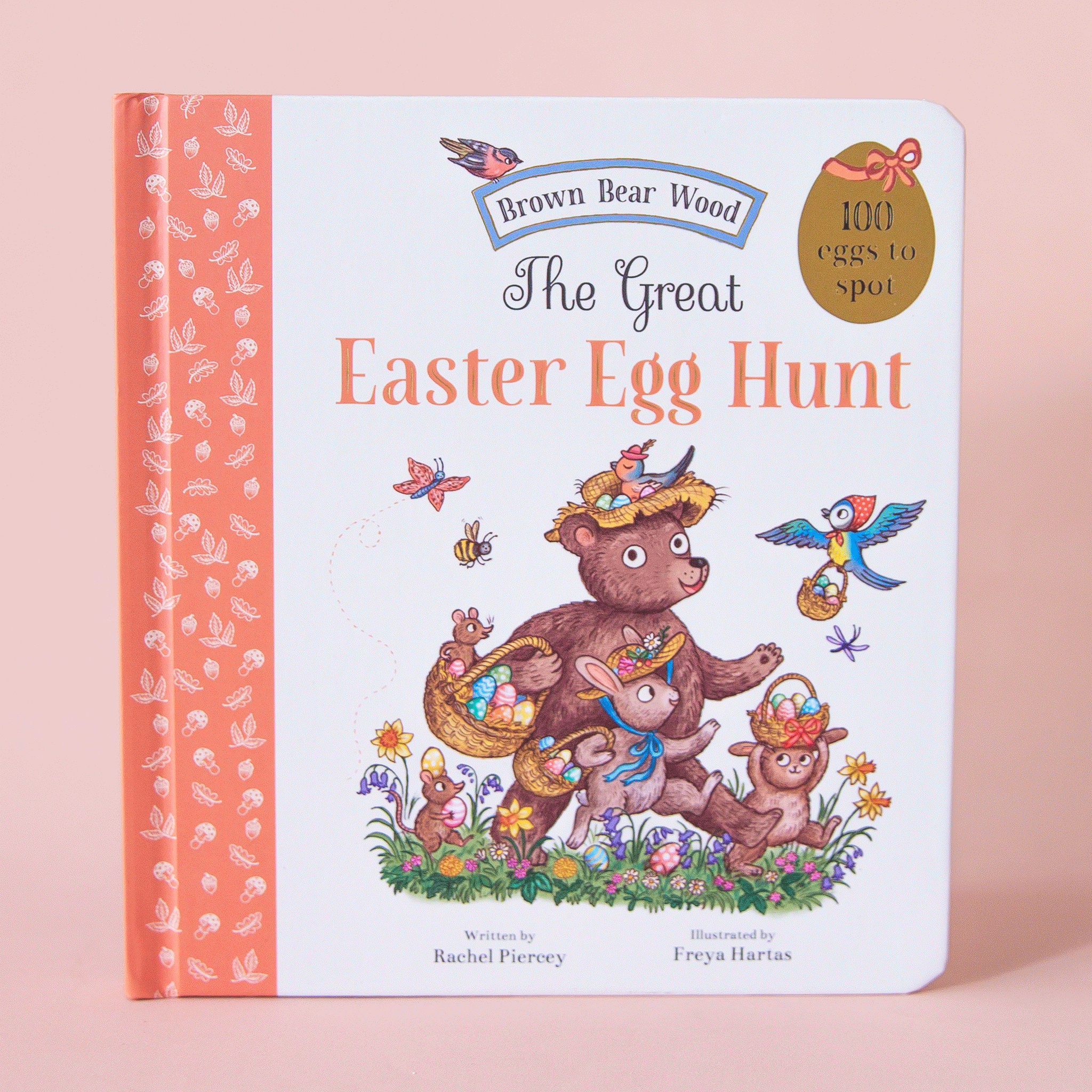 On a pink background is a white and orange book cover with an illustration of a group of woodland animals holding baskets with easter eggs inside along with the title above it that reads, &quot;The Great Easter Egg Hunt&quot;.