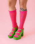 A pair of fuchsia colored striped socks with a ruffle detail at the top.