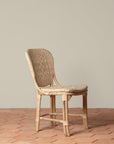 On an ivory background is a rattan chair with a woven rattan seat and backrest.