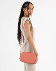 woman wearing coral colored crossbody