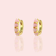 Two pink opal and gold huggie hoop earrings.
