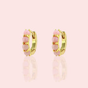 Two pink opal and gold huggie hoop earrings.
