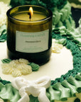 A glass jar candle with a white lablel that reads, 'Flamingo Estate Prinsesstarta'.