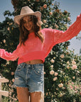 A model wearing a pink sequin cropped sweater.