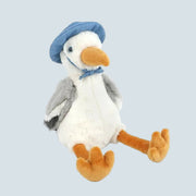 A white seagull shaped stuffed animal wearing a blue hat.