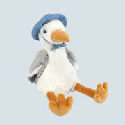 A white seagull shaped stuffed animal wearing a blue hat.