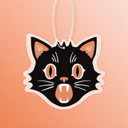 A black and orange air freshener in the shape of a black cat.