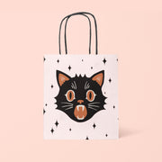 A white gift bag with a graphic of a black cat and black handles.
