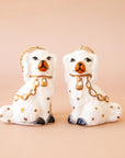 A pair of white dog shaped ornaments.