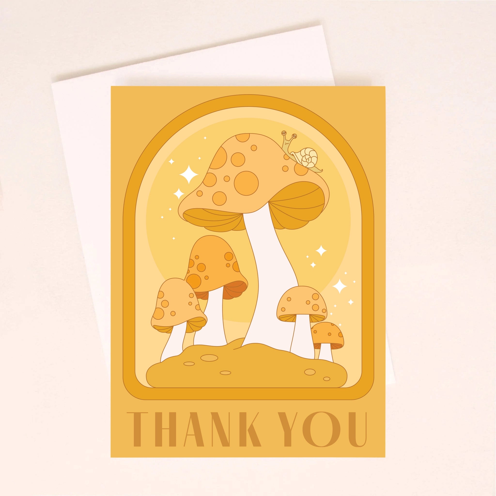 On an ivory background is an orange greeting card with an arched design, mushroom illustrations with a little snail on top of the largest one and text along the bottom that reads, &quot;Thank You&quot;.