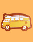 This vinyl sticker has a classic daffodil yellow VW Bug with a surfboard fastened on top, providing that classic beach cruiser vibe. The sticker has tawny brown bubble border.