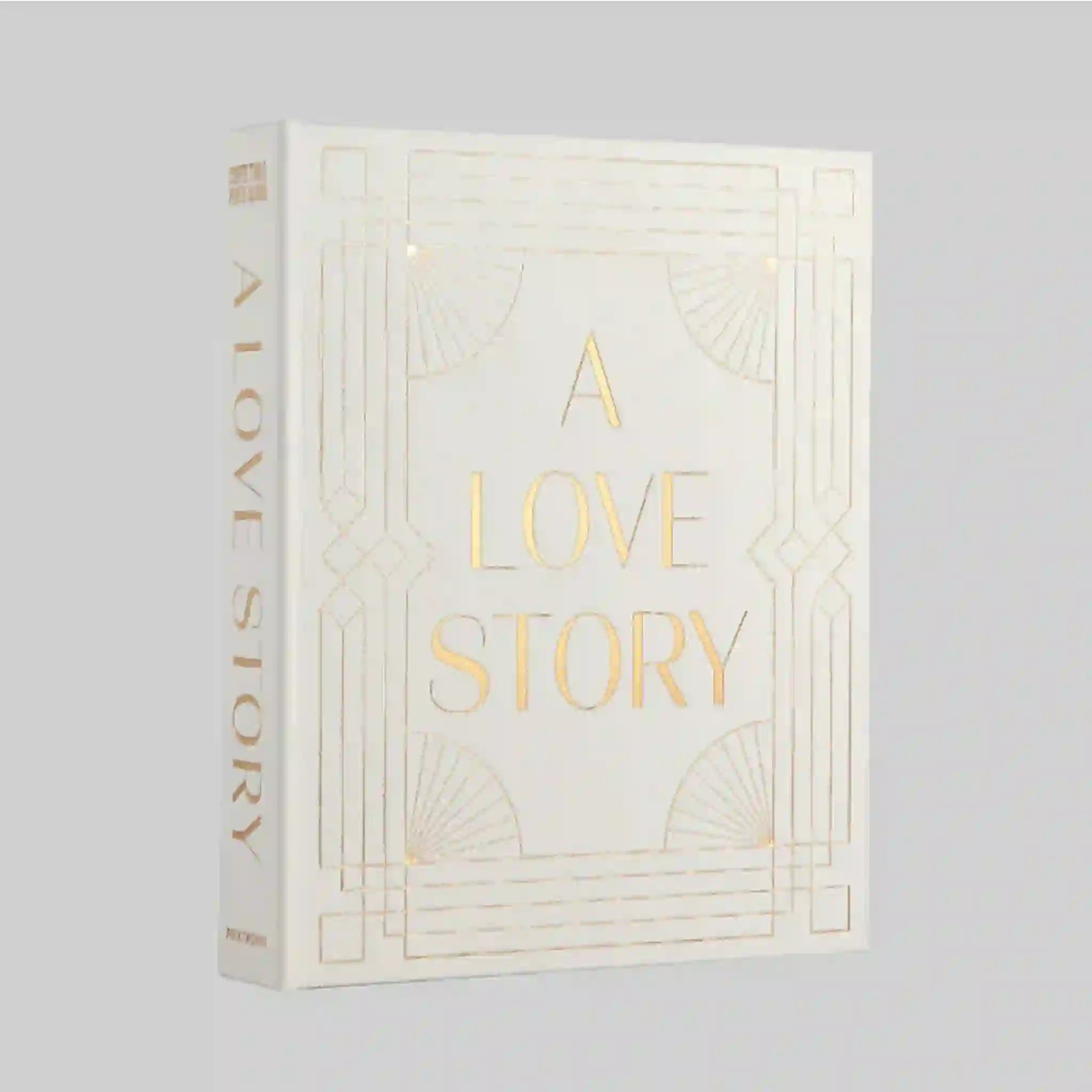 On a grey background is an ivory photo album cover with gold text that reads, &quot;A Love Story&quot;. 