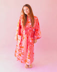 A cotton robe with pockets and an orange and hot pink tropical floral print.