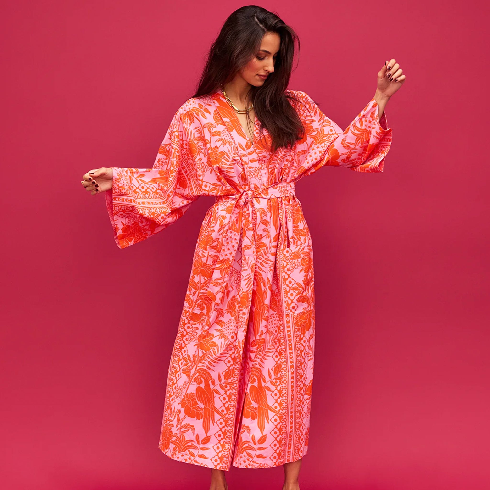 A cotton robe with pockets and an orange and hot pink tropical floral print. 