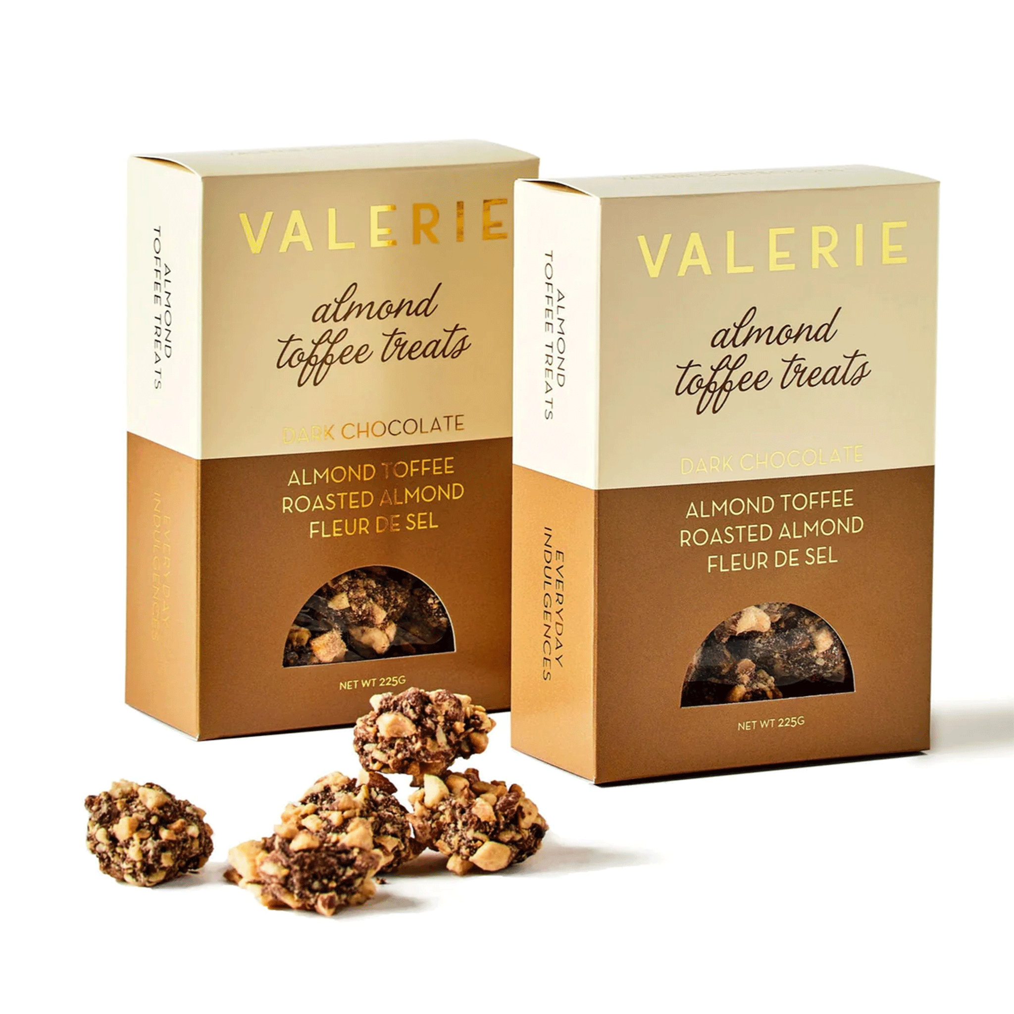 On a white background is two boxes of Almond Toffee Treats with gold text on the front of the box. The toffee treats are small clusters of almond, chocolate and toffee bits. 