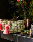 A green and ivory terry cloth pouch with a pink tassel.
