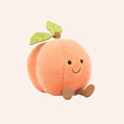 A peach shaped stuffed toy with a smiling face and little feet and legs.