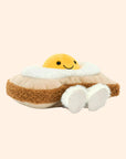A tan and yellow toast and egg shaped stuffed toy with a smiling face.