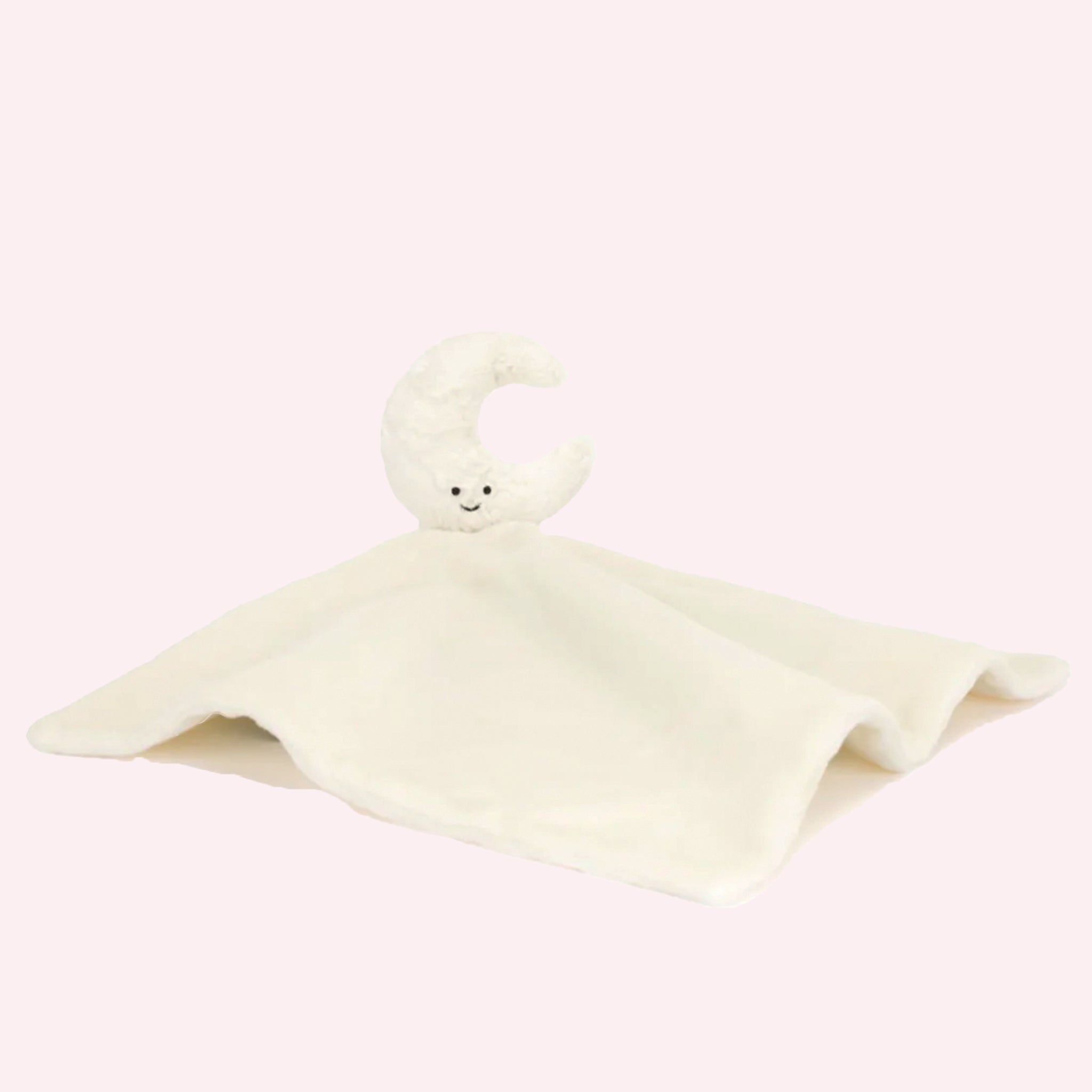 On a pink background is an ivory colored crescent moon shaped stuffed toy attached to a fuzzy soother blanket.  