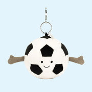 On a blue background is a black and white soccer ball shaped bag charm.