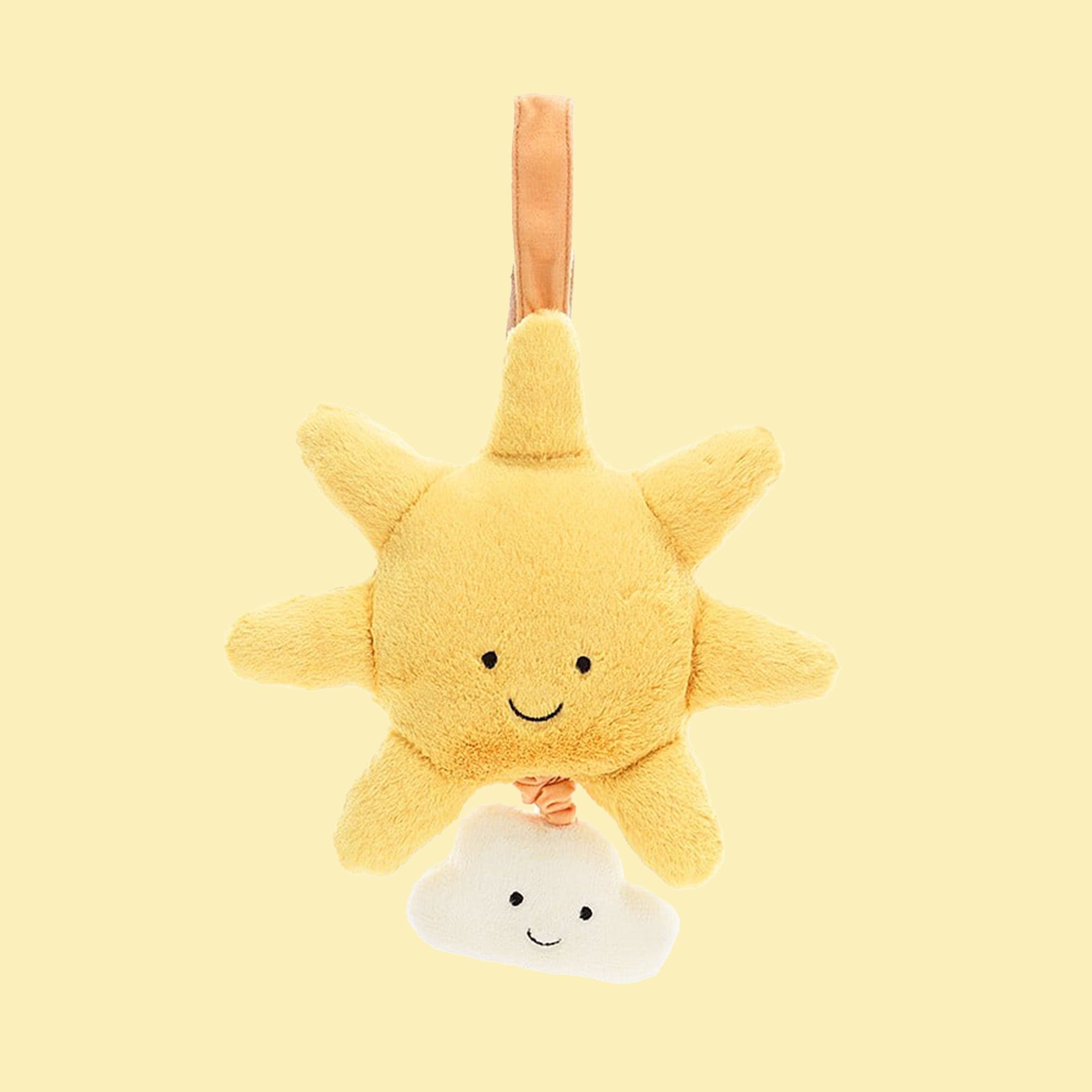 On a yellow background is a yellow sun and cloud shaped stuffed toy with a retractable pull and velcro loop for hanging. 