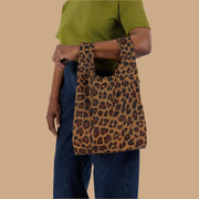 A small nylon tote bag in a leopard print that folds up into a small pouch.