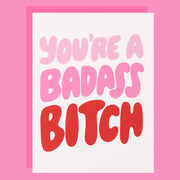 Motivational quote 'You're a badass bitch' in pink and red on a pink background