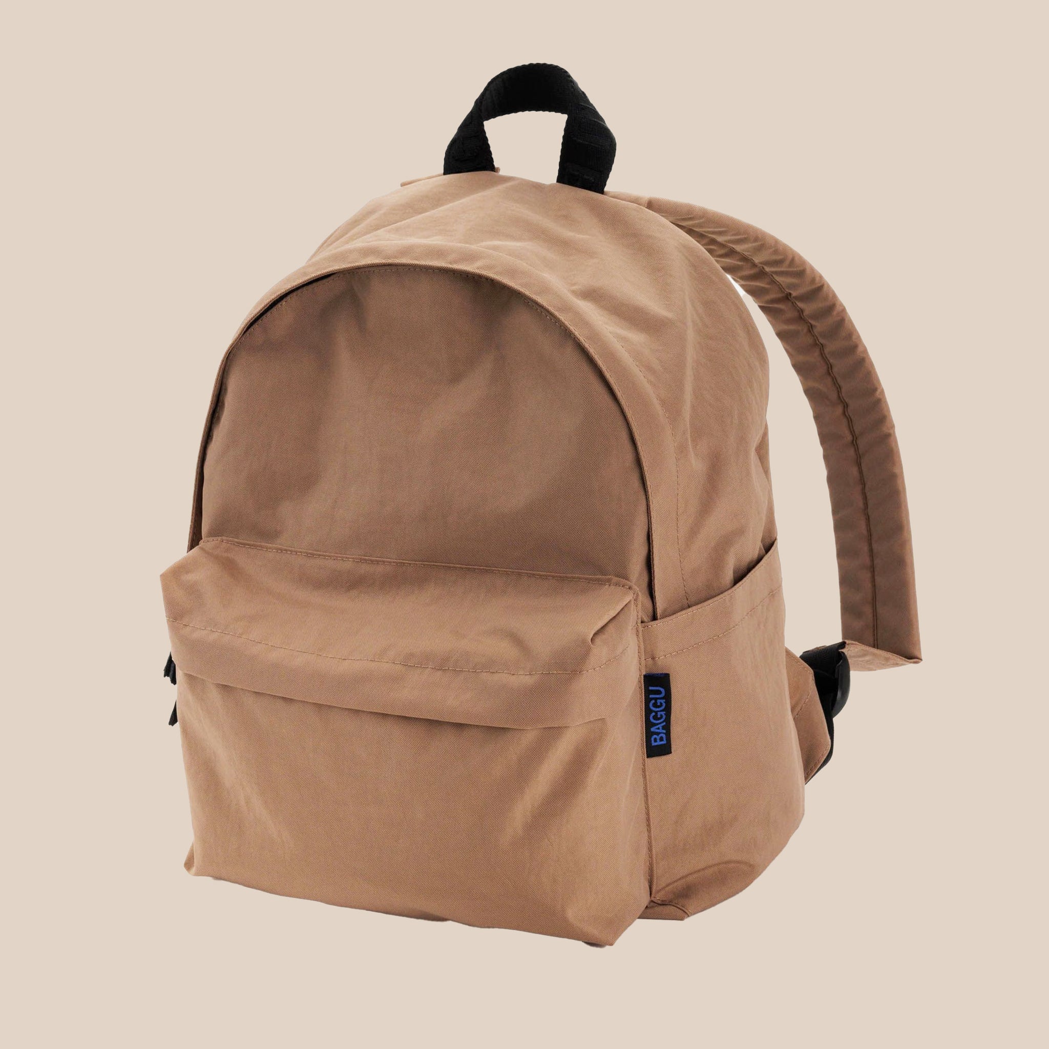 A nylon backpack in a tannish brown color with black straps and two front zipper compartments. 