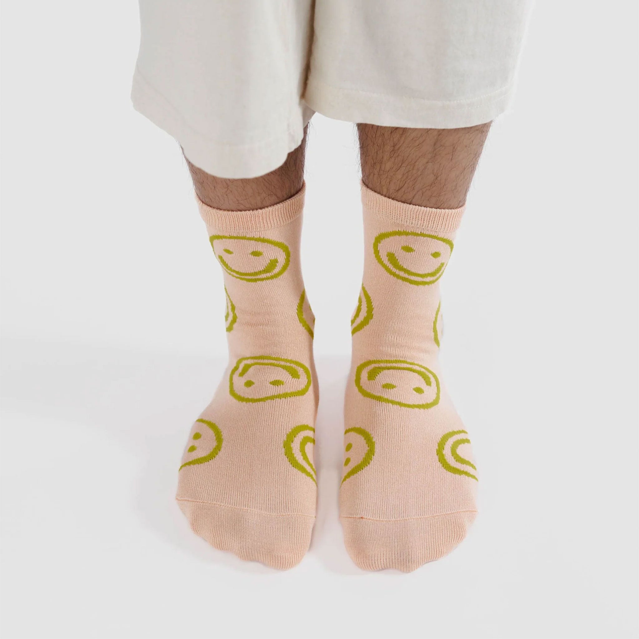 light pink socks with green smiley faces