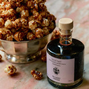 A glass bottle of aged balsamic vinegar with a cork top.