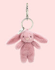 A pink bunny shaped bag charm with silver hanging loop details.