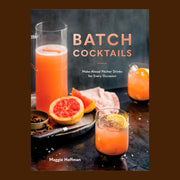 Cocktail book titled "Batch Cocktails. Make-Ahead Pitcher Drinks for Every Occasion. Maggie Hoffman." The cover image shows a tray with a pitcher of tangerine liquid, a sliced blood orange, and a knife. Two tangerine colored cocktails with lemon garnishes sit beside the tray.