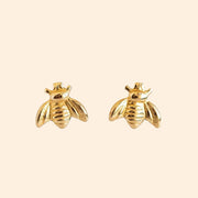 A gold pair of bee shaped earrings.