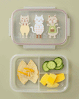 On a green background is a clear plastic bento box with three kitty graphics on the lid filled here with a lunch.