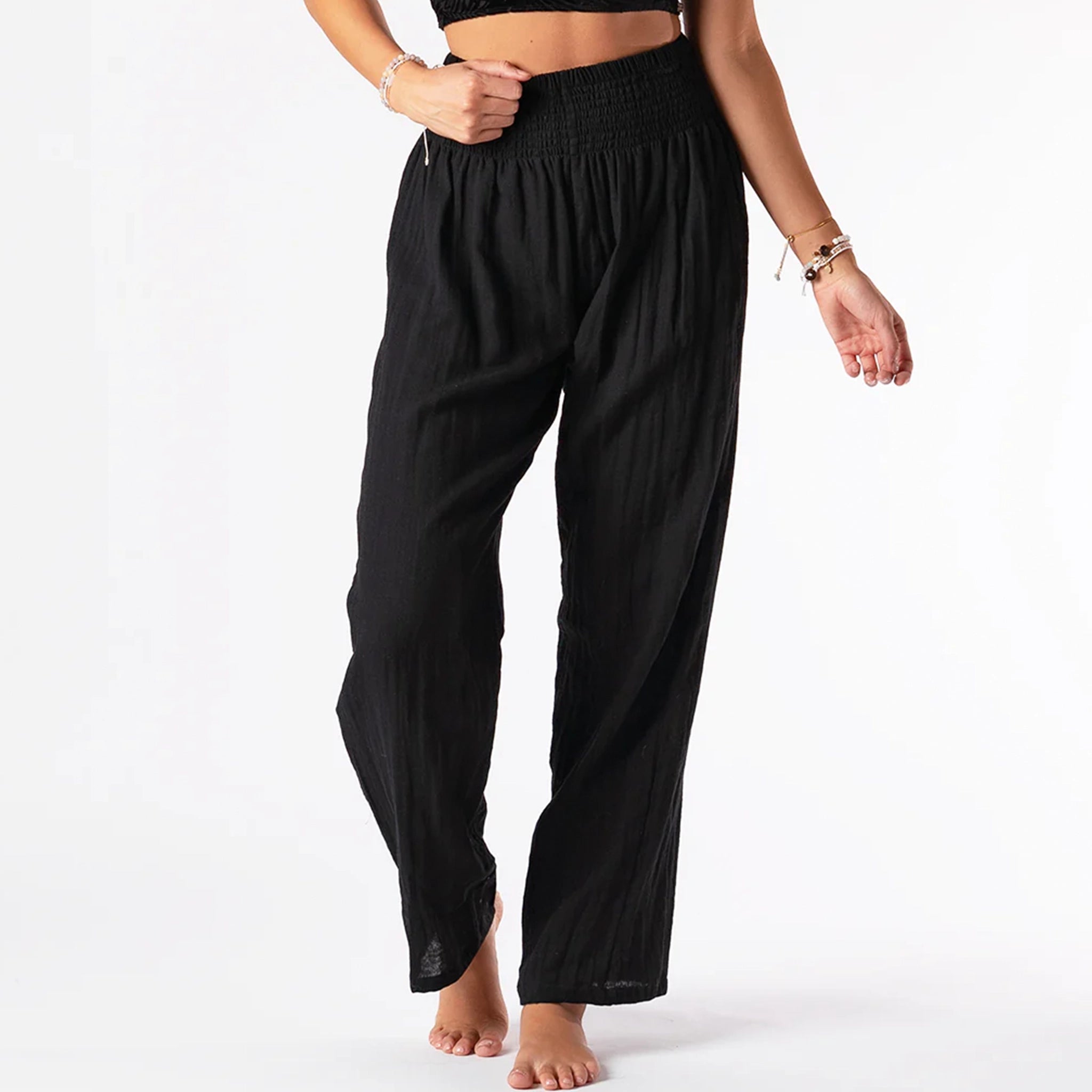On a white background is a pair of black cotton wide leg pants with an elastic waistband. 