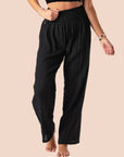On a white background is a pair of black cotton wide leg pants with an elastic waistband.