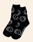 A pair of black socks with white smiley faces on them.