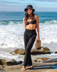 A model wearing a pair of black cotton wide leg pants with an elastic waistband.