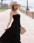 A black tiered maxi dress with spaghetti straps.