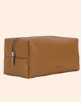 A warm brown vegan leather toiletry / cosmetic bag with a zipper closure and handle on one side.