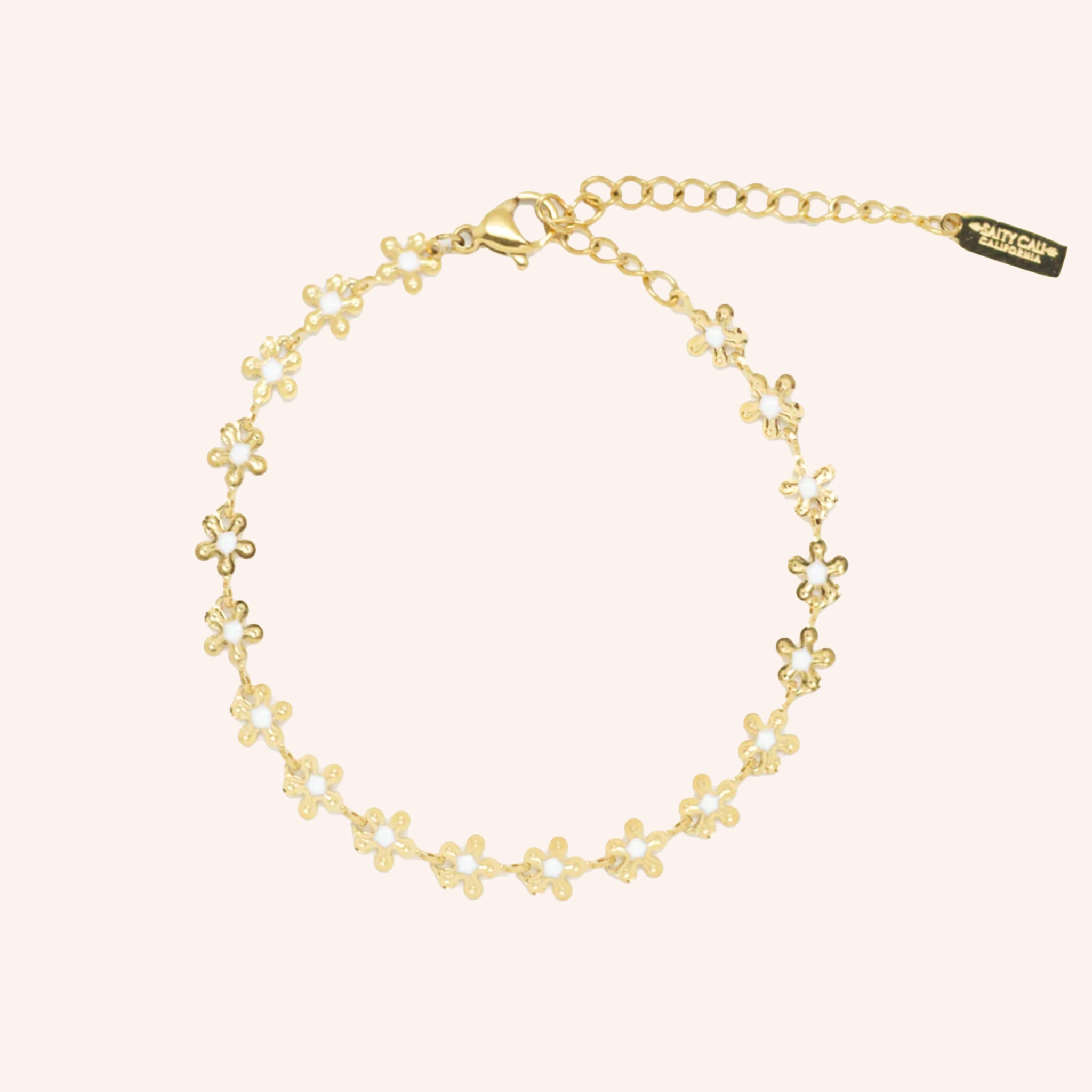 A gold bracelet with daisy shaped chains and white centers. 