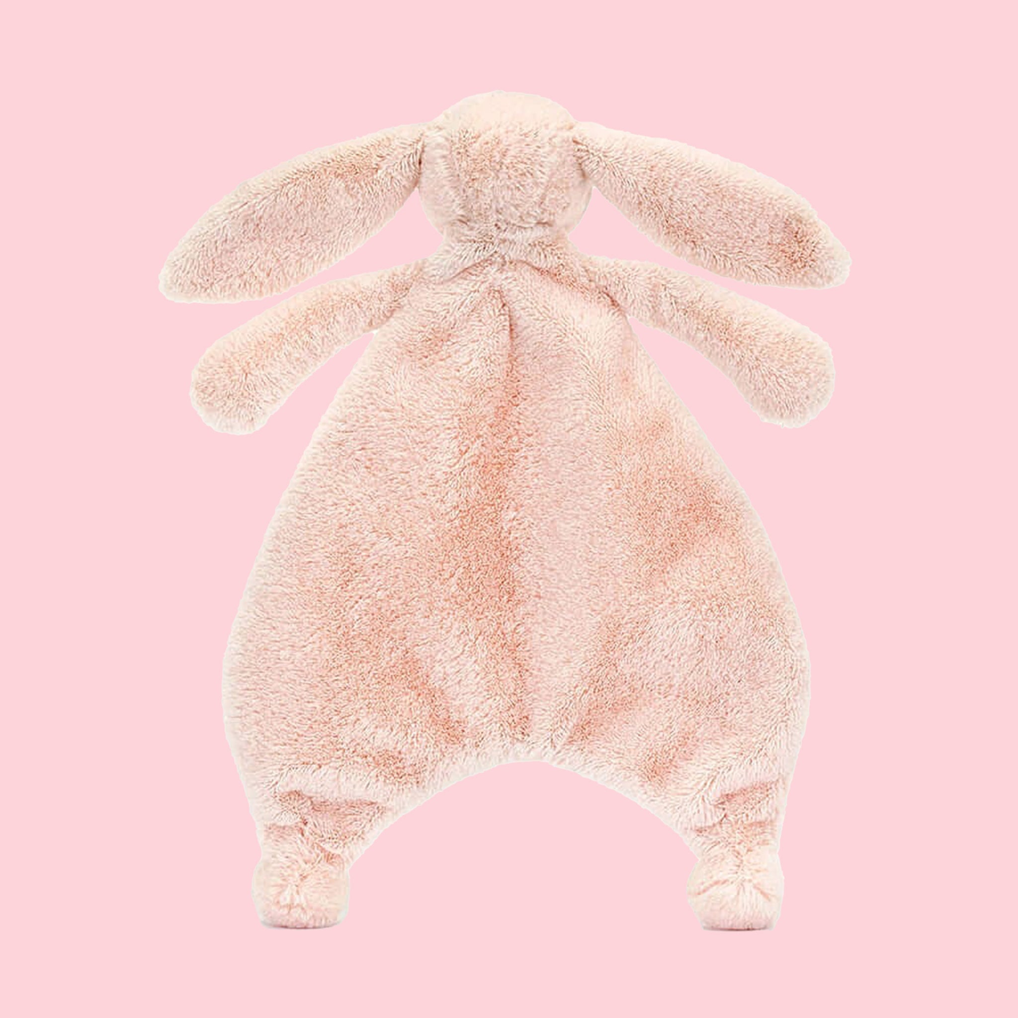 A blush pink bunny shaped furry unstuffed blanket/ toy.